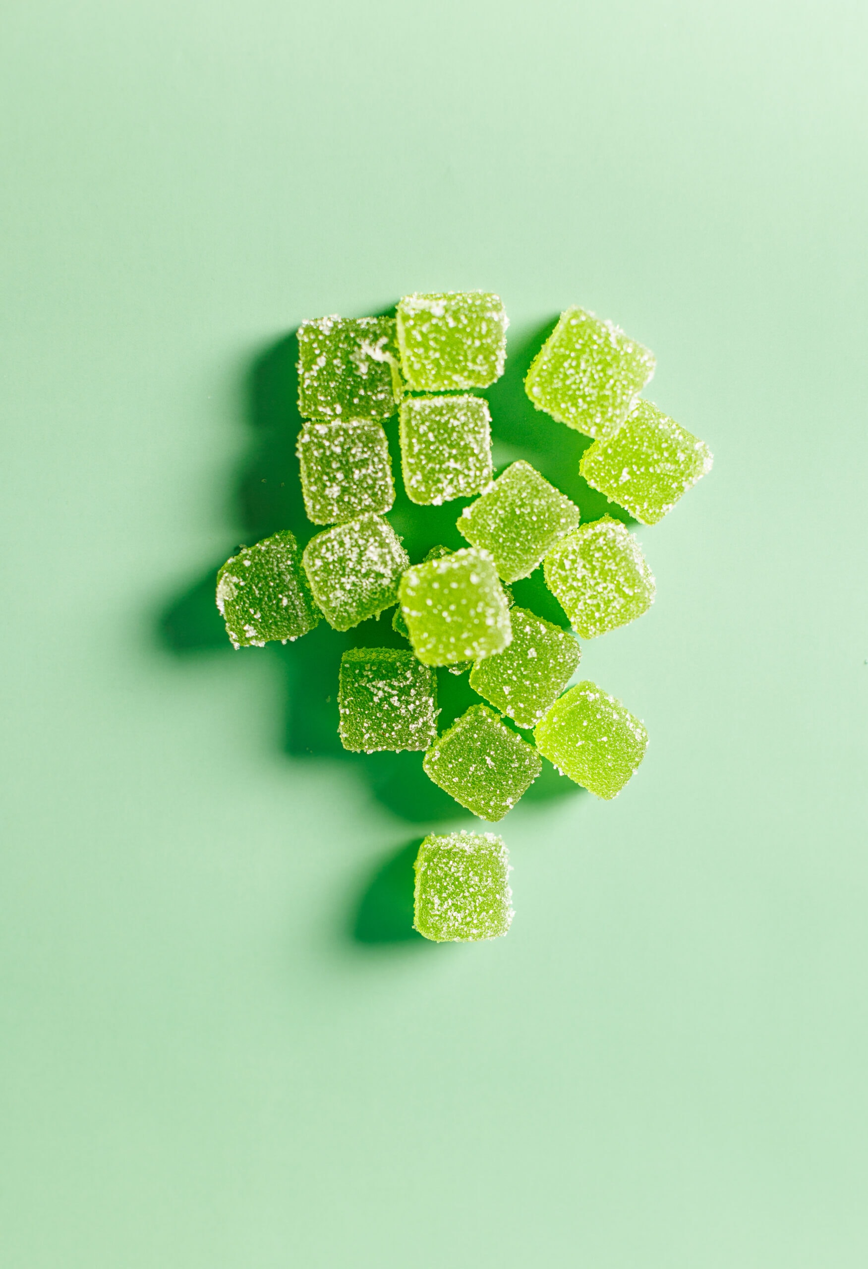 Green sugar cubes, gourmet candy, confectionery, sugar snacks, colorful sweets, bright green candies, sugar-coated treats, dessert ingredients, playful sweets, vibrant candy photography.