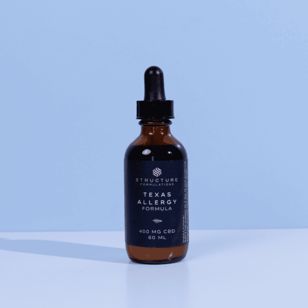 Cbd allergy relief formula dropper bottle with black label on light blue background.