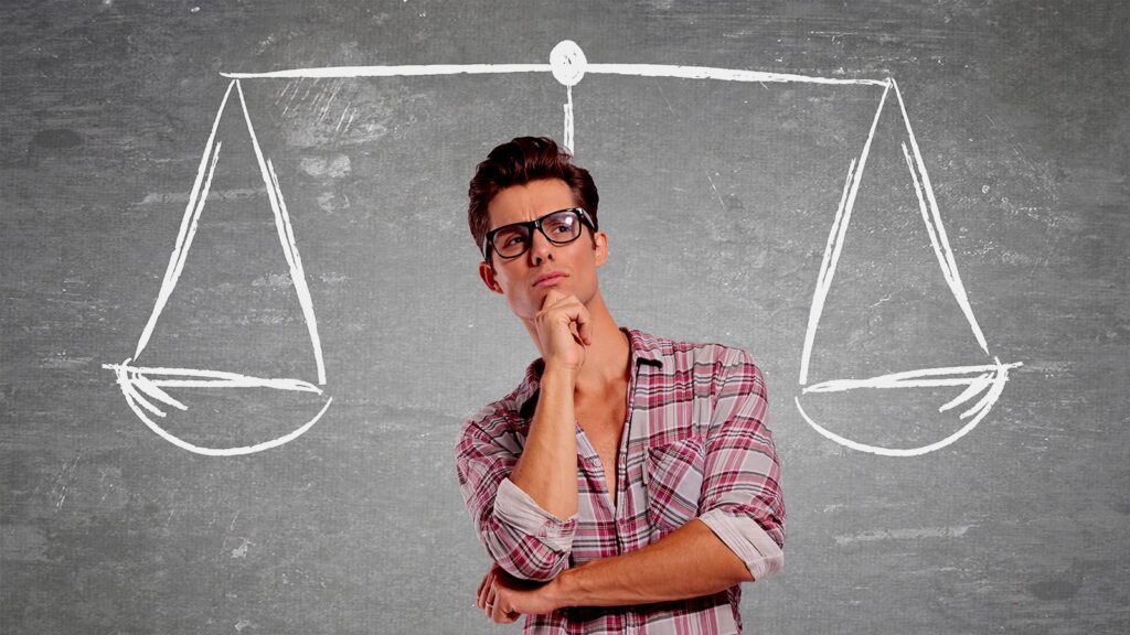 Thoughtful man with glasses pondering over drawn scales of justice on chalkboard wall.